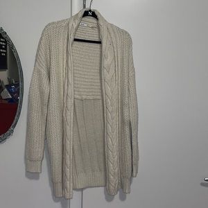 Cream cable knit sweater with pockets.
